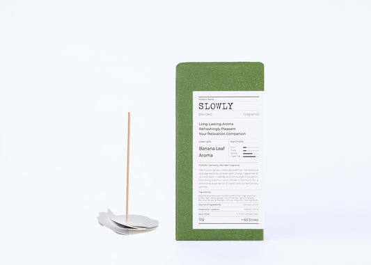 Incense stick with packaging labeled 'SLOWLY' on a white background