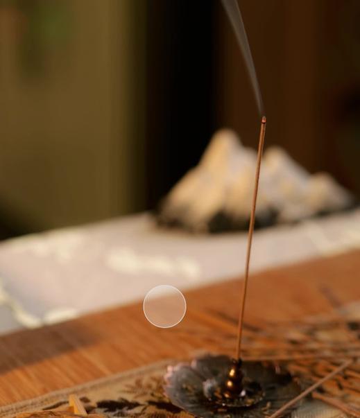 Monian Agarwood incense stick burning in a bronze holder, creating a calm Zen atmosphere with soft rising smoke.