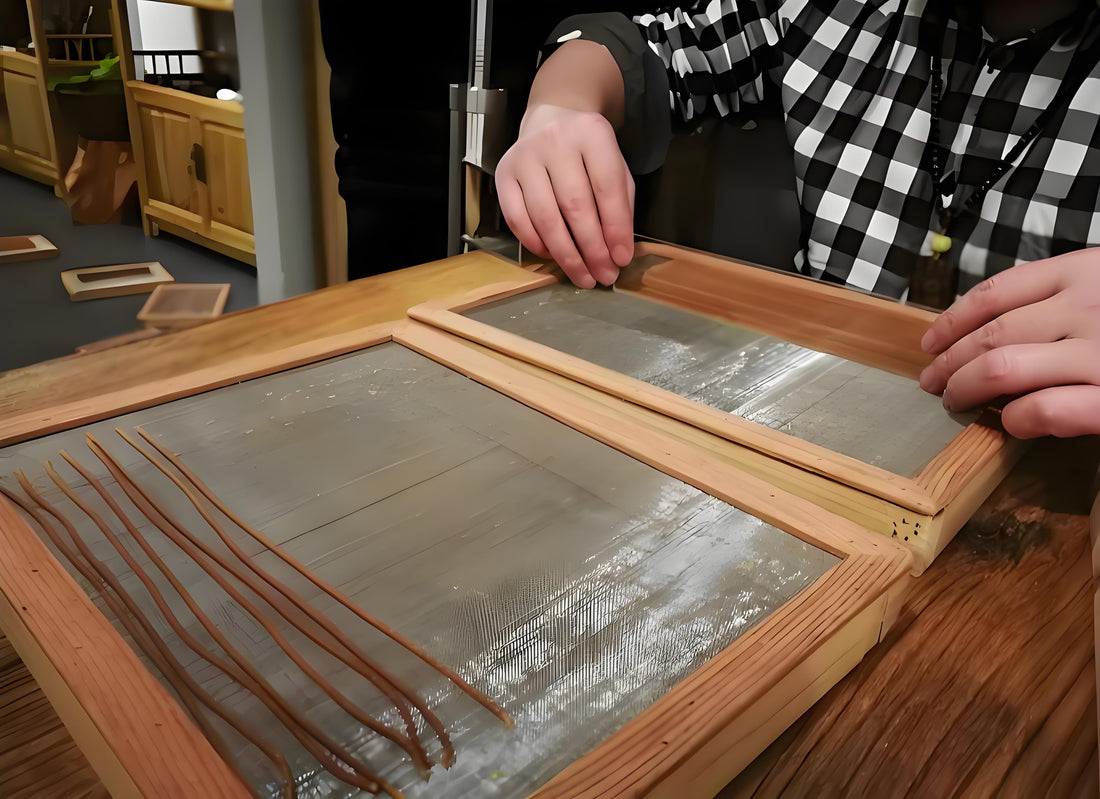 Person crafting incense sticks by hand using a wooden frame mold on a workbench, in a traditional-style interior.