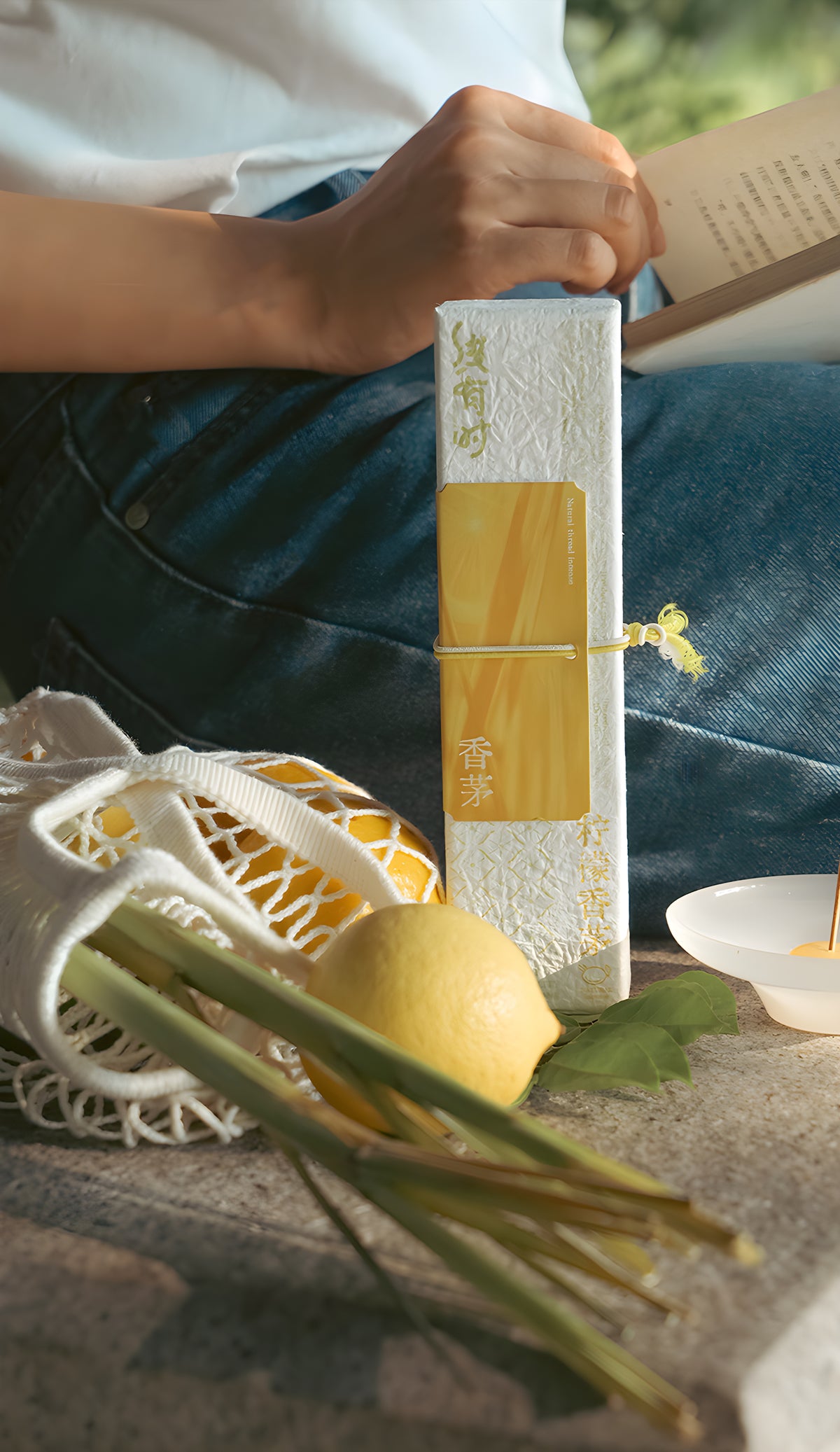 Lemongrass incense box displayed beside a tea setting with lemon and green stems.