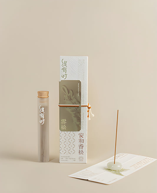 Cedar incense packaging and a slim storage tube beside an upright incense stick in a round holder.