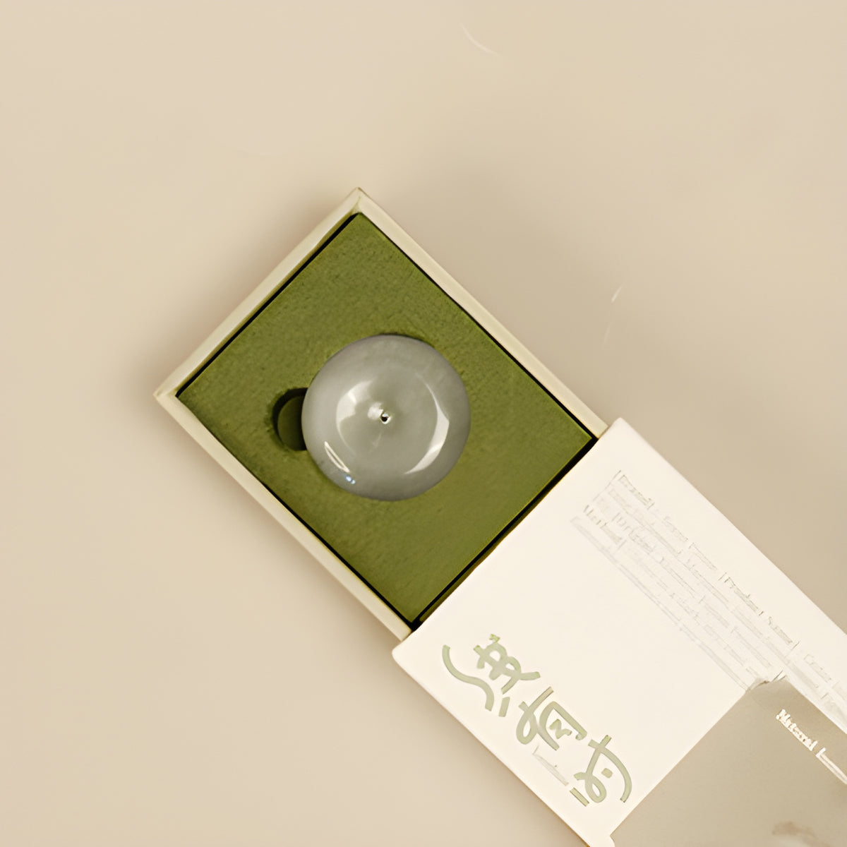 Round incense holder nestled in the olive-green tray of the cedar incense box.