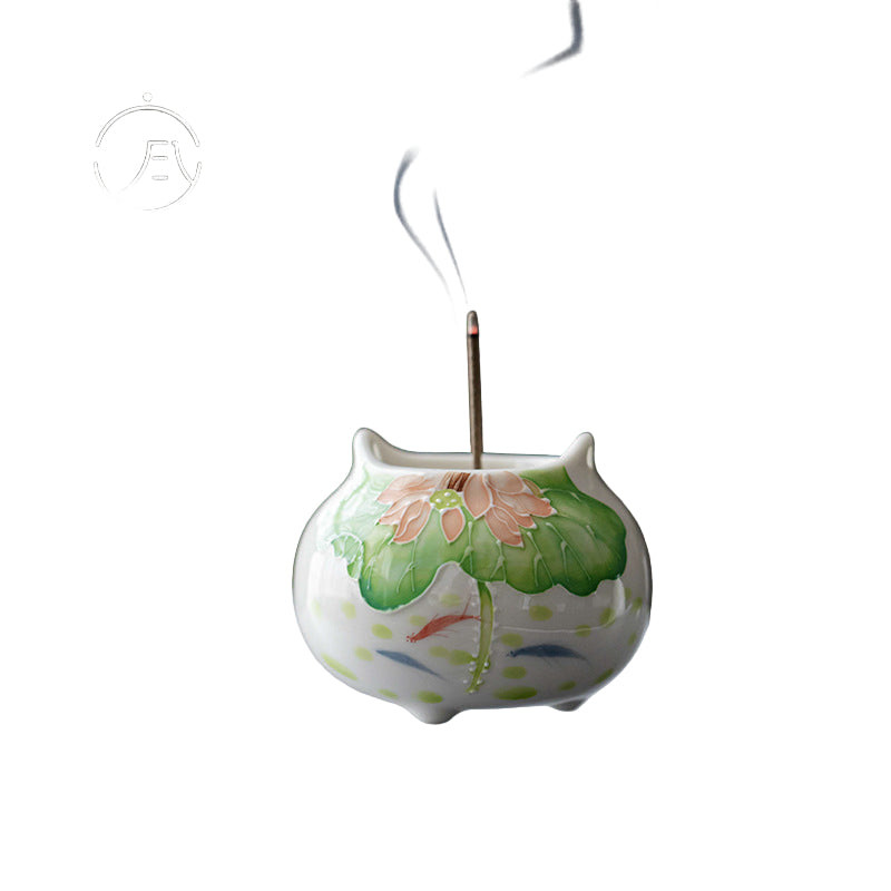 Ceramic incense burner with lotus design on a dark background