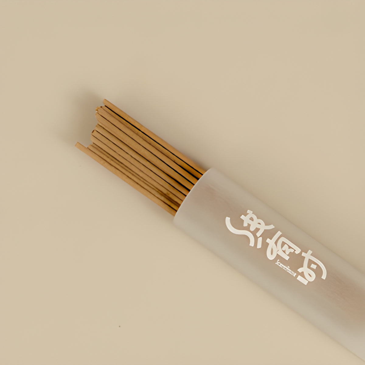 Close-up of lemongrass incense sticks extending from their storage tube.