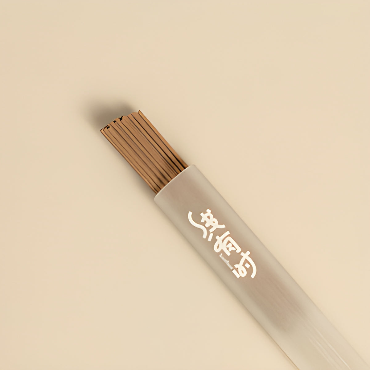 Close-up of melon note incense sticks extending from their storage tube.