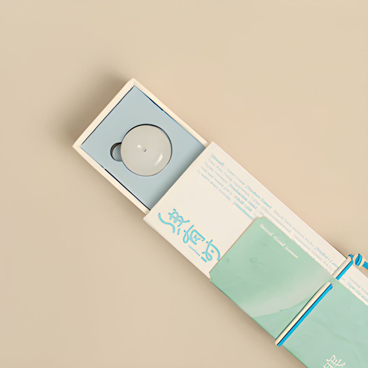 Pale round incense holder nestled inside the white-and-teal melon note incense box.