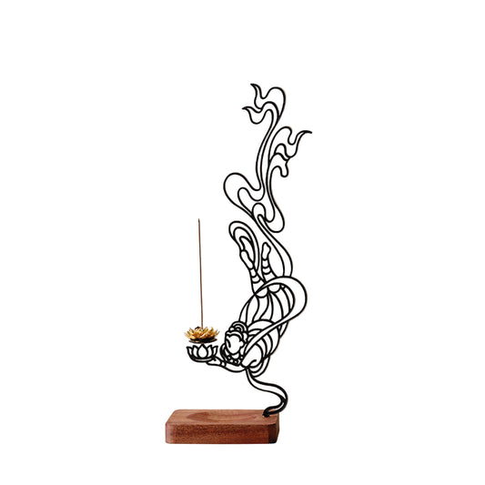 Decorative metal sculpture of a figure holding a lotus flower with incense on a beige background