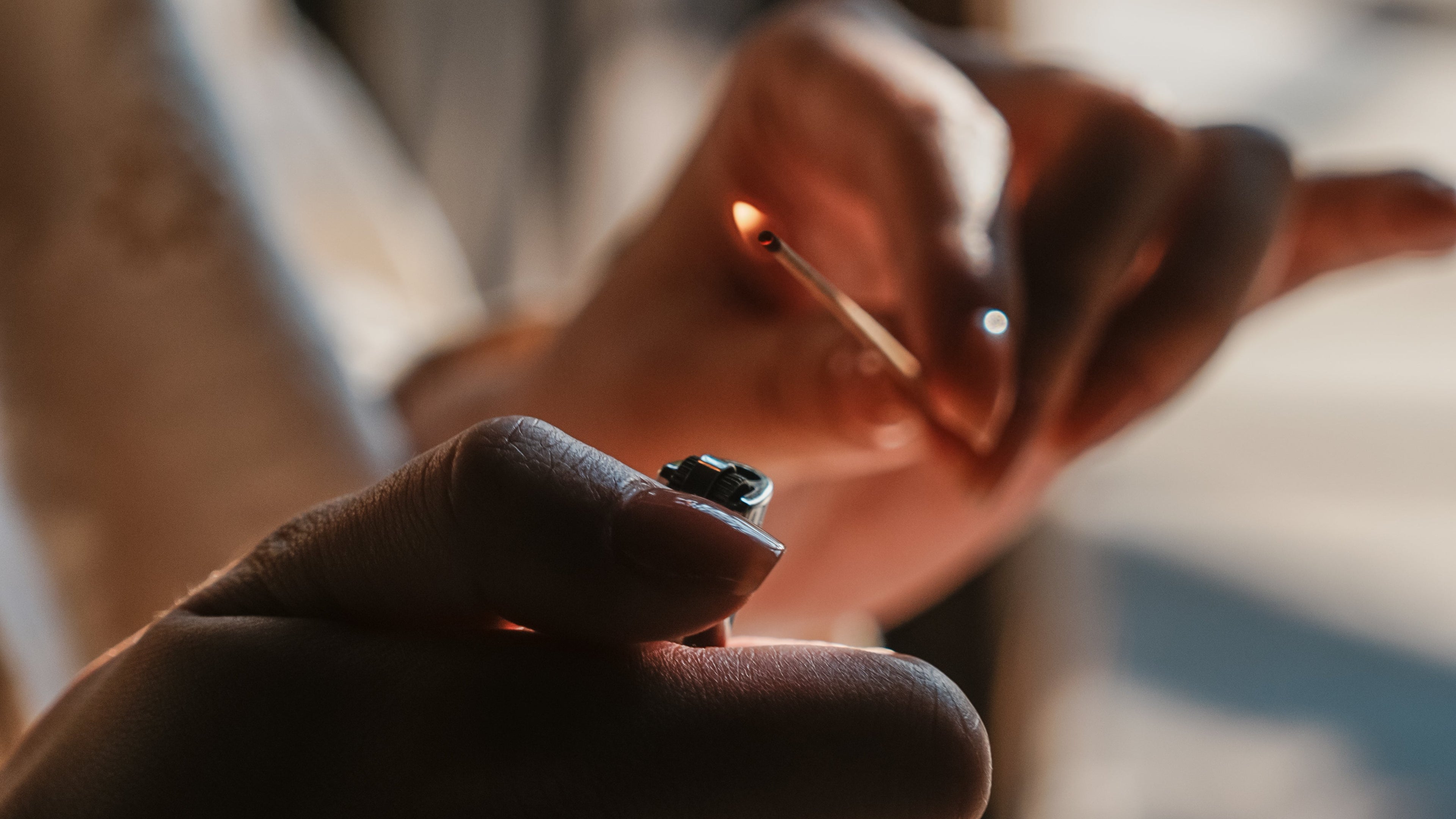 Person lighting a match with a matchbox, blurred background