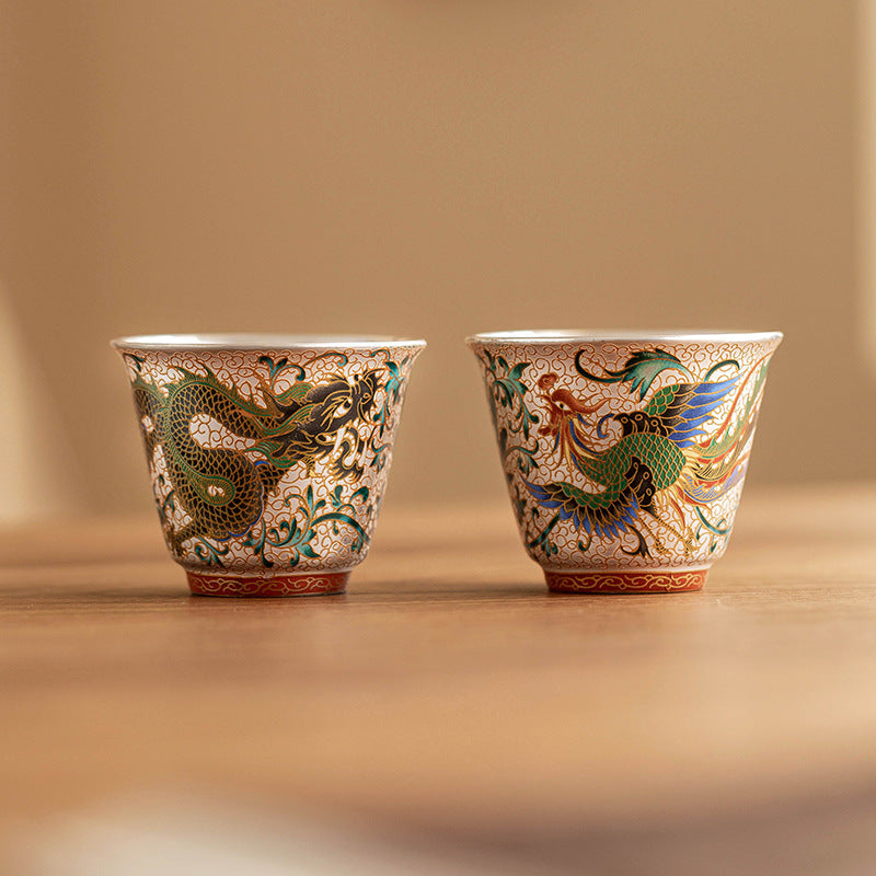 Close-up of cloisonné enamel dragon and phoenix pattern teacup pair