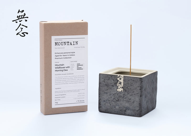 Grey cube-shaped incense burner beside a Mountain incense box.