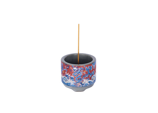Decorative incense holder with red and blue dragon design on a white background